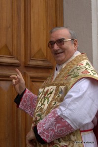 don Angelo mentre aspetta una risposta dopo aver bussato (Foto Feliciana Mariotti) 